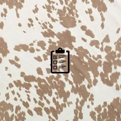 a brown and white spotted wallpaper with a clipboard on it's side