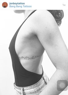 the back of a woman's left shoulder with an inscription on her right side