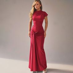 a woman in a long red dress posing for the camera with her hands on her hips