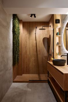 a modern bathroom with wood paneling and a large mirror on the wall above the sink