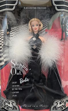 a barbie doll in a black dress with white fur