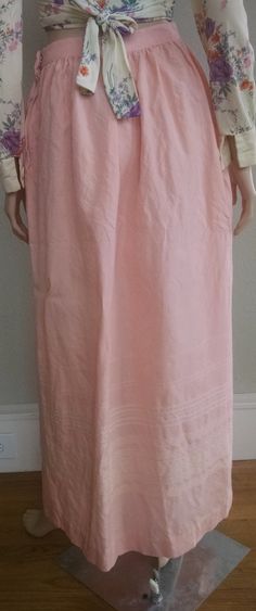 "This is a romantic high-waist pink maxi skirt from the 1950's. It is a delicate pink color with subtle cream embroidery at the bottom. The high waist quickly flares to a generous hip measurements (see below for exact measurements). Zipper and hook-and-eye closure on the left side, no pockets. The skirt fits like a modern small with the limiting factoring being the high waist measurement. The skirt is not lined and the fabric feels like a wool blend with a little stiffness and itchy-ness to it. Pink Fitted Maxi Skirt With Elastic Waistband, Fitted Pink Maxi Skirt With Elastic Waistband, Feminine Relaxed Maxi Skirt, Feminine Full Gathered Maxi Skirt, Pink Fitted Maxi Skirt, Pink Full Maxi Skirt For Spring, Pink Pleated Feminine Maxi Skirt, Feminine Pink Pleated Maxi Skirt, Spring Long Inseam Flowy Skirt