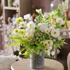 a vase filled with white flowers sitting on top of a table next to a chair