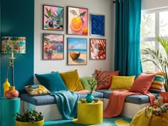 a colorful living room with blue curtains and pictures on the wall