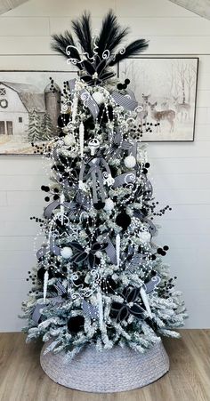 a white christmas tree with black and silver decorations