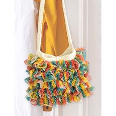 a purse hanging on the side of a white door with yellow and blue ruffles