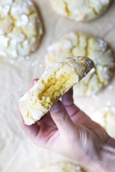 a hand holding up a half eaten biscuit with powdered sugar on the top