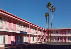 pink motels with palm trees in the parking lot