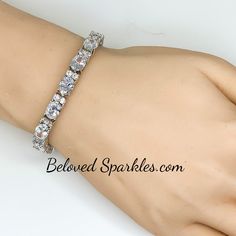 Lily Oval Cubic Zirconia 28ct Silver Tennis Bracelet. This statement tennis style is created with oval and round cubic zirconia. This luxe piece paired with glistening accompaniments is perfected compliment for the event attire. Only the best quality cubic zirconia is use on our fine jewelry collection. Our genuine rhodium finish is achieved using an electroplating process that coats the item with heavy layers of rhodium, a close cousin to platinum, which gives our jewelry a platinum luster. Thi White Crystal Tennis Bracelet For Anniversary, White Crystal Tennis Bracelet For Party, Anniversary White Crystal Tennis Bracelet, White Bling Bracelets For Formal Occasions, Formal White Bling Bracelets, White Round Tennis Bracelet For Party, White Bling Bracelets For Anniversary, Oval Cubic Zirconia Tennis Bracelet For Wedding, Wedding Oval Cubic Zirconia Tennis Bracelet