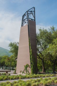 a tall tower with a clock on it's side in the middle of a park