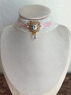 The "Princess at Heart" choker Hand crafted choker perfect for coquette / balletcore / cottagecore / princess / kawaii / dolly / angel / vintage styles. This choker is made with white lace, pink satin ribbon, a crystal charm, and an iridescent bead. lace choker, ribbon choker, heart choker, pink choker, heart necklace, heart charm, costume jewelry, cosplay jewelry Great stocking stuffer, Christmas present, festive. Pink Ribbon Wedding Jewelry, Cute Pink Choker For Party, Pink Vintage Choker Jewelry, Cute White Jewelry With Ribbon, Elegant Handmade Pink Choker, Adjustable Wedding Choker For Valentine's Day, Feminine Adjustable Ribbon Jewelry, Cute Adjustable Choker For Parties, Cute Adjustable Ribbon Jewelry