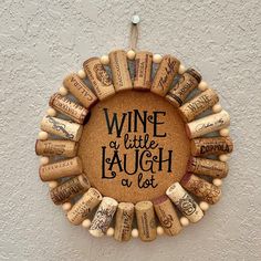 a wine cork wreath hanging on the side of a wall with words written in it