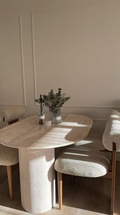 a table and chairs in a room with white walls