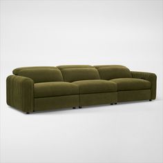 a green couch sitting on top of a white floor