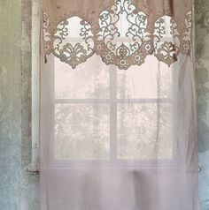 a window with a curtain hanging from it's side in front of a wall