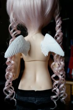 a doll with pink hair and white wings