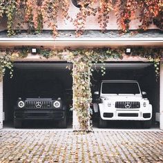 two cars parked in front of a building with ivy growing on the side of it