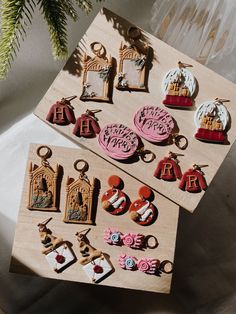 two wooden magnets with charms on them sitting next to a christmas ornament