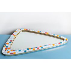 a decorative tray with multicolored tiles on the bottom and gold trim around the edge