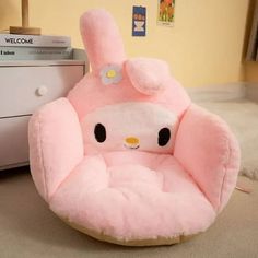 a pink hello kitty chair sitting on top of a floor next to a white dresser