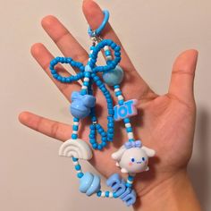 a hand is holding several small beads and charms in the shape of an elephant, sheep, giraffe