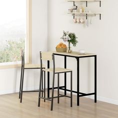 a small table with two chairs next to it in front of a wall mounted shelf