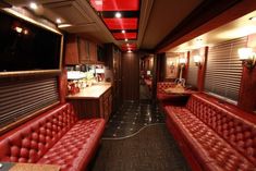 the inside of a train car with red leather seats and counter tops on each side