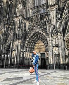 a woman standing in front of a large cathedral