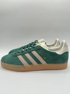 Elevate your sneaker game with these Adidas Men's Gazelle Originals in Size 9. The green and beige colorway, featuring a low top shoe shaft style and lace-up closure, is perfect for any occasion, whether it's activewear or just a stylish look. The shoe width is standard, and the size code is IF7154. These sneakers are part of the Adidas Gazelle product line, and they are designed for walking, running, and jogging. They were manufactured in 2024, and they are not vintage or customized. The shoe is made by Adidas, a well-known brand in the athletic shoe industry. These sneakers are perfect for any man looking for a comfortable and stylish shoe. Green Low-top Skate Shoes With Contrast Sole, Green High-top Sneakers With Gum Sole For Streetwear, Green High-top Sneakers For Streetwear, Green Sporty Skate Shoes With Gum Sole, Green Custom Lace-up Sneakers With Contrast Sole, Green Lace-up Custom Sneakers With Contrast Sole, Green Skate Shoes With Gum Sole For Streetwear, Green Sneakers With Gum Sole For Streetwear, Green High-top Skate Shoes With Contrast Sole