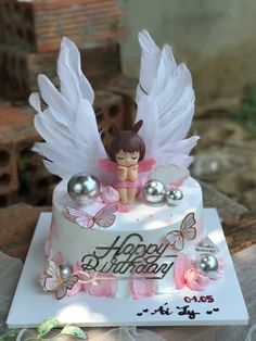 a birthday cake with an angel decoration on top