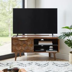 a living room scene with focus on the entertainment center and large window in the background