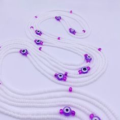 purple and white beaded necklaces with evil eyes on each strand, along with pink beads