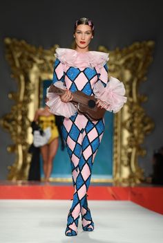 a model walks down the runway in a pink and blue outfit