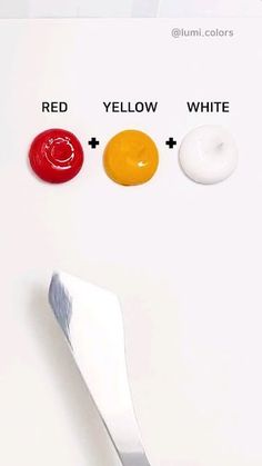 a white table with three different colored buttons and a spoon on top of the board