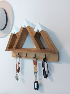 a hat hanging on a wall with key hooks and keys attached to it's sides