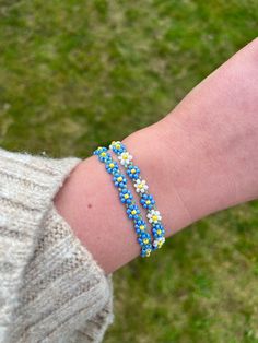 Handmade Beaded Forget Me Not Bracelet with gold colour findings. Adjustable forget me not bracelet available in two variations: -Forget Me Not -Forget Me Not and Daisy Please select your chosen colour from the menu when placing your order. Bracelet fits sizes between 16-19cm with use of extender chain. Please note some threads may be visible as this is a handmade product. Ensure to keep this piece out of water and avoid contact with fragrances and lotions as this can make the colours fade. Plea Blue Flower Beaded Bracelets For Beach, Blue Flower Bracelets For Beach, Blue Bracelets With Tiny Beads For Friendship, Blue Flower Bracelets For Friendship, Blue Flower Friendship Bracelets Gift, Blue Flower Shaped Beaded Bracelet For Gift, Blue Flower Bracelet For Friendship, Light Blue Beaded Flower Jewelry, Blue Bohemian Flower Bracelets