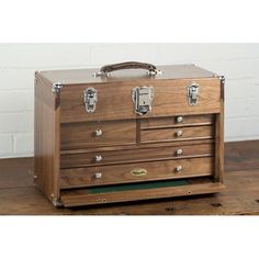 an old wooden chest with drawers and handles on the bottom shelf, sitting on top of a wood floor