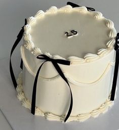 a large white cake with black ribbon around it