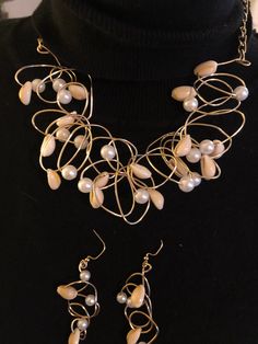 "\"BEACH PARTY\" Wire is twisted into an avant-garde maze, strung with 8 mm pearls and smaller size cowrie shells. Select gold or silver. The necklace measures 18 inches with chains attached to include a lobster claw clasp  for closing and adjusting to a smaller size. If 18 inches is too small, please message me for a longer neckline. Pierce earrings hang to 2 inches, and  are a fine match, made with smaller pearls and smaller cowrie shells. A beautiful expression of summer! Jewelry will arrive Bohemian Pearl Jewelry For Party, Party Wire Wrapped Pearl Jewelry, Unique Pearl Jewelry For Party, Adjustable Metal Pearl Necklace For Party, Elegant Beaded Spiral Jewelry, Unique Pearl Drop Jewelry For Party, Bohemian Pearl Charm Party Jewelry, Gold Bohemian Pearl Necklace For Party, Bohemian Gold Pearl Necklace For Party