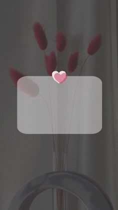 a vase with some pink flowers in it and a heart on the top of it