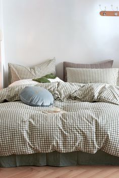 an unmade bed with pillows and blankets on it in a room that has wooden floors