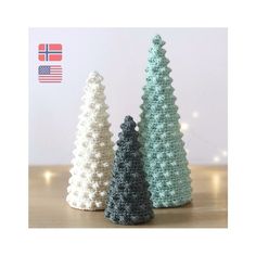 three crocheted christmas trees sitting on top of a table next to each other