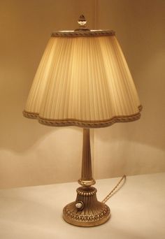 a lamp that is on a table with a chain hanging from it's side