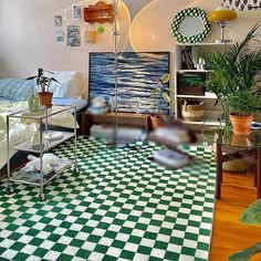 a room with green and white checkered flooring, potted plants and bookshelves