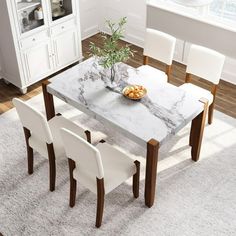 a dining room table with white chairs and a marble top