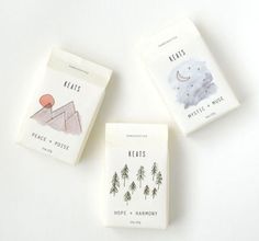 three books are sitting next to each other on a white surface with trees and mountains in the background