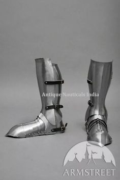 a pair of armor boots with straps and buckles on the sides, sitting next to each other