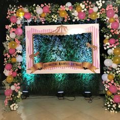 a decorated stage with balloons and flowers for a birthday or baby's first birthday