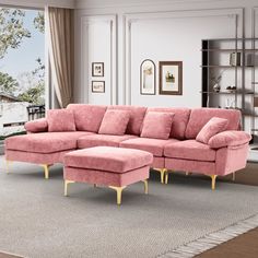 a living room with a pink couch and ottoman