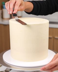 a person cutting into a cake with a knife